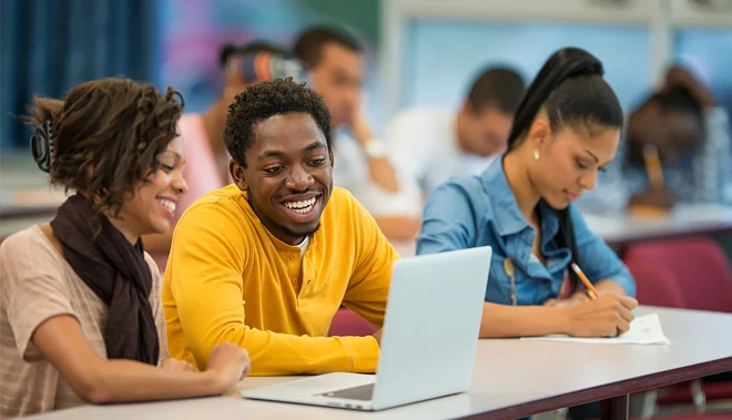 Estudante de intercâmbio com colegas ao fundo, quanto tempo é o ideal para uma viagem de estudos?